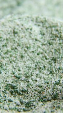 The brush stirs the crumbly substance. Pale green powder is kneaded with a brush. Macro. ASM video. The texture of the green substance. Macro. ASM video.