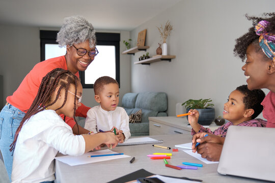 African mothers painting with their children during the freetime. Horizontal extended family.