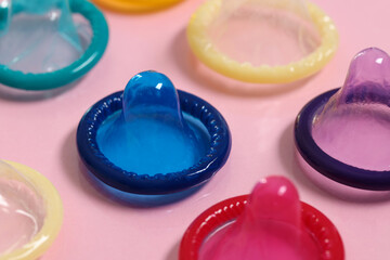 Condoms on pink background, closeup. Safe sex