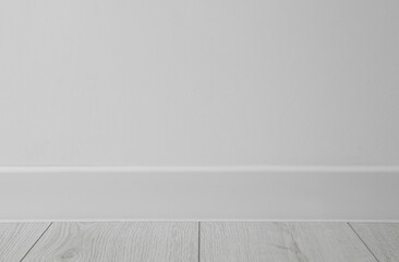 White plinth on laminated floor near wall indoors