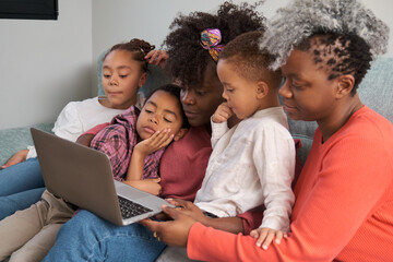 Happy african horizontal extended family seeing something on the laptop at home.