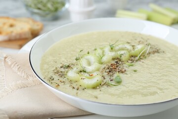 Bowl of delicious celery soup on table, closeup