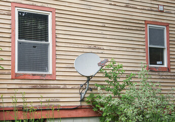 The satellite dish and radio antennas atop houses represent the transformative power of technology,...
