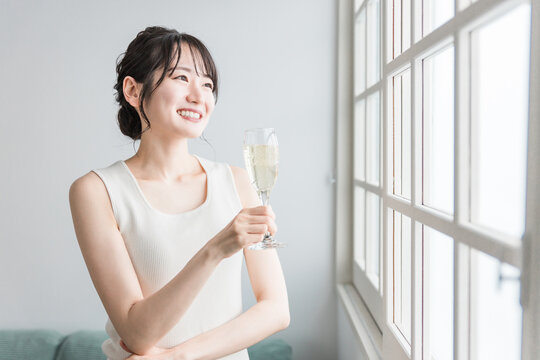 家で昼間にシャンパン・炭酸水・炭酸飲料を飲む女性
