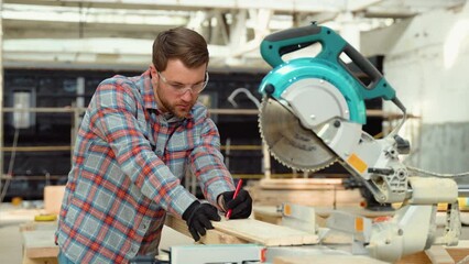 Building contractor worker using hand held worm drive circular saw to cut boards on a new home constructiion project