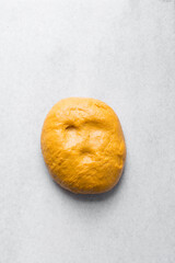 Checking if dough is proofed using poke test, dough with an indent in a white bowl, process of making bread, cheddar cheese bread dough shaped into a ball