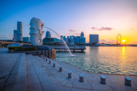 SINGAPORE-APRIL 30, 2018: Merlion statue fountain in Merlion Park and Singapore city skyline at sunrise sky morning. Merlion fountain is one of the most famous tourist attraction in Singapore.