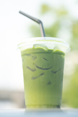 Iced matcha green tea in glass with nature background.