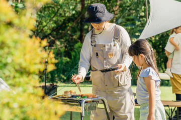 キャンプ場でバーベキューをする家族・ファミリー
