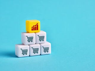 Increase in sales volume and business growth. Shopping cart and ascending graph on cubes.