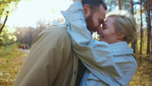 strong relationship between husband and wife, happy smiling blonde woman and handsome bearded man kissing in park , have great time together, couple adore each other, romantic moments Slow motion