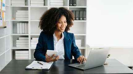 African Woman freelancer is working her job on computer tablet and laptop Doing accounting analysis report real estate investment data, Financial at office