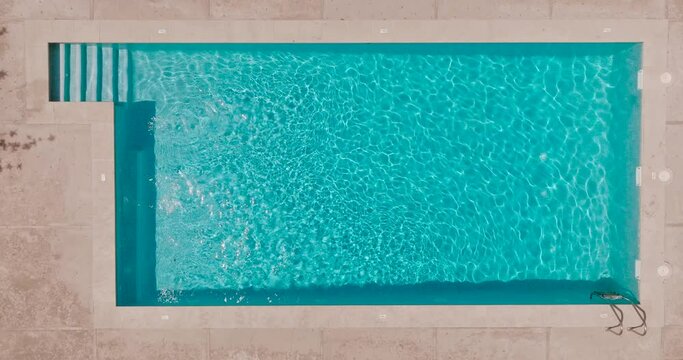 Blue water in the swimming pool with light reflections.