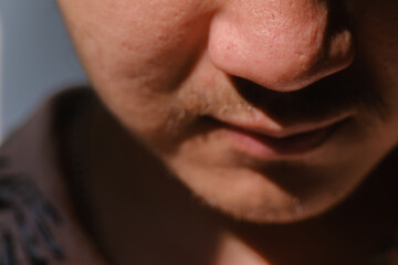 Close-up and soft focus shot of a man's partial face with a little mustache and beard. Bokeh or blurred background.