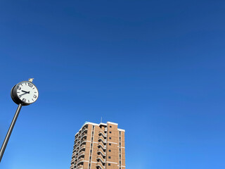 青空に高層ビルと時計