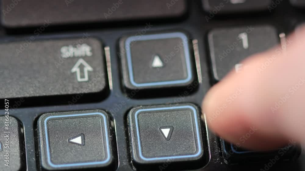 Poster finger presses on the arrow button on the laptop keyboard