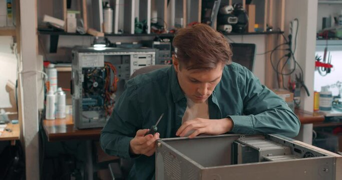 young engineer unscrews the bolts pf the computer with a screwdriver Slow motion Broken computer disassembling, Repairman take apart CPU to find failure reason. Electronic repair, renovation concept