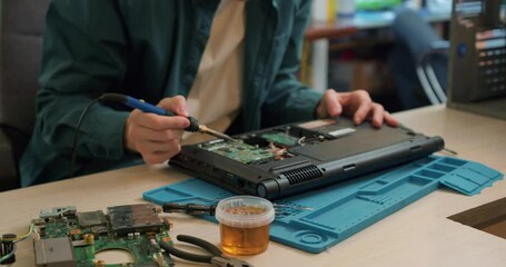 specialist holds a soldering iron in his hand and solders a microcircuit Slow motion Technician engineer in workshop. Technician repairing pcb layout with soldering iron.