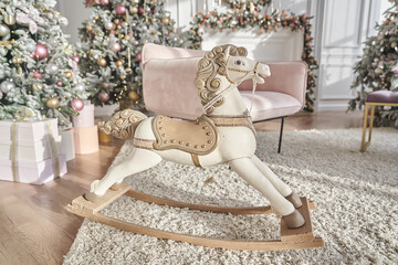 Children's swing in the form of a horse, made by hand from natural light wood on the background of...