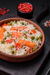 Delicious boiled rice with vegetables or risotto with salt, spices and herbs