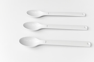 White plastic spoons for camping, isolated on white surface
