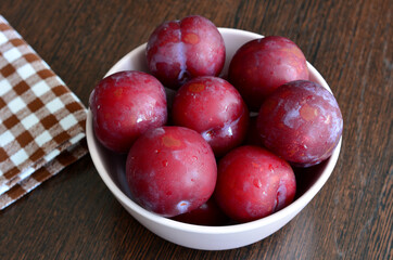 purple plums with dots in the bowl, copy space 