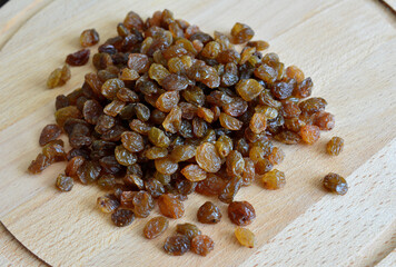 heap of raisin isolated on wooden background, close up  