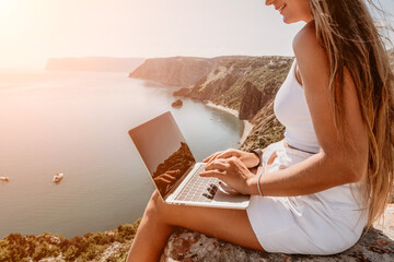 Digital nomad, Business woman working on laptop by the sea. Pretty lady typing on computer by the...