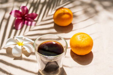 Close up cup coffee against palm shade background.