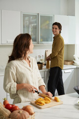 Happy young couple cooking dinner in kitchen together