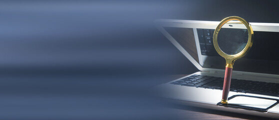 Magnifying glass on the computer keyboard.