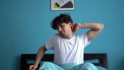 Arabic man wake up in the morning in bed yawns and rubs his eyes, tired and sleepy