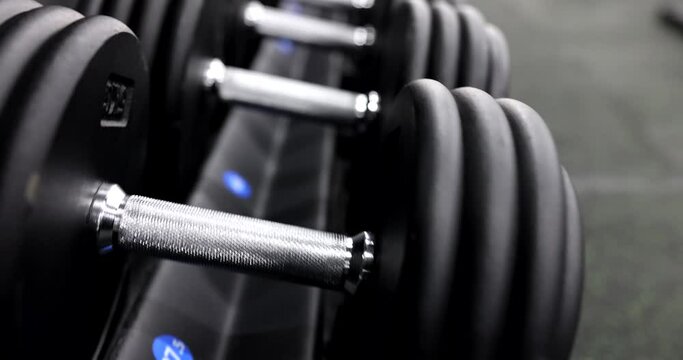 Sports dumbbells in gym concept. Sports equipment for strength exercises in weightlifting and bodybuilding