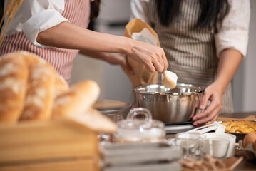An Asian woman finds joy in her culinary creativity as she lovingly prepares homemade bakery goods...