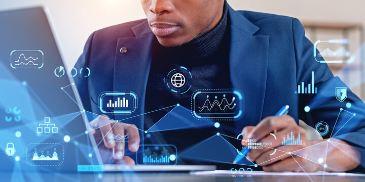 Man using laptop with network interface and taking notes