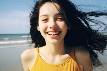 Beautiful close-up portrait of a young woman on a beach smiling into the camera