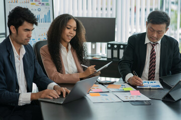 A group of Asian business people stand to talk about the company's project.