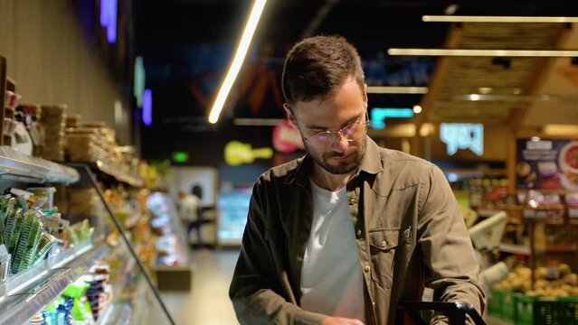 Man shopping cheese in grocery store