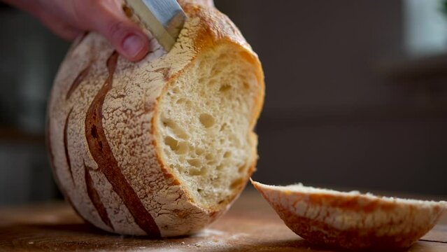Slicing freshly baked bread on a cutting board 4k footage