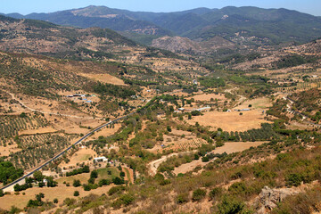 A landscape with a mountain view and a winding road against a blue sky in the city of Bergama, near Izmir, Turkey