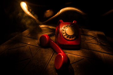 old black telephone on old wood plank with art dark background with fog and toned light. empty space.