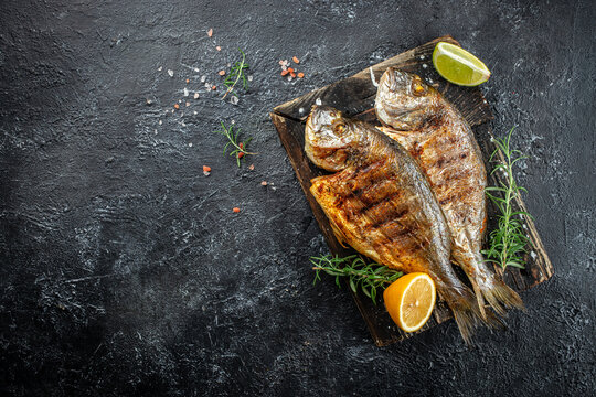 delicious grilled dorado or sea bream fish with lemon. banner, menu, recipe place for text, top view