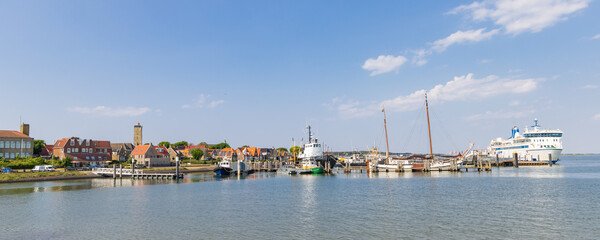 Fototapeta na wymiar Cityscape West-Terschelling with tugboat Hunter in the harbor at Wadden island Terschelling in Friesland province in The Netherlands