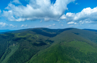 aerial view with mountains and valleys covered with green forest. Landscape from the Carpathian mountains in summer