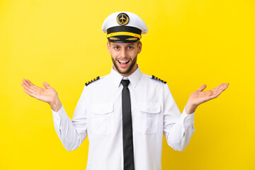 Airplane caucasian pilot isolated on yellow background with shocked facial expression © luismolinero