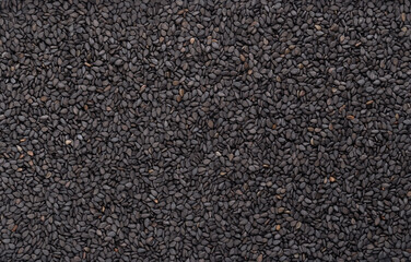 Black sesame, from above. Unhulled seeds of Sesamum indicum, with rich and nutty flavor, and with one of the highest oil content of any seed. Used in Asian cuisine. Background, close-up, food photo.