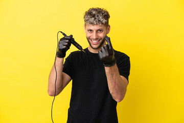 Tattoo artist caucasian man isolated on yellow background making money gesture