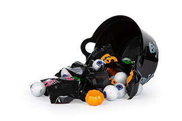 A halloween candy bowl there is tipped over to the side, with candy falling out, isolated on a white