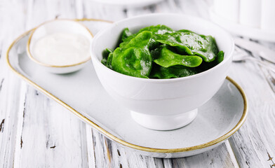 Tasty green dumplings on white bowl