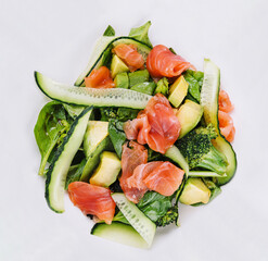 Salmon avocado salad with salted fish, lettuce, broccoli and cucumbers